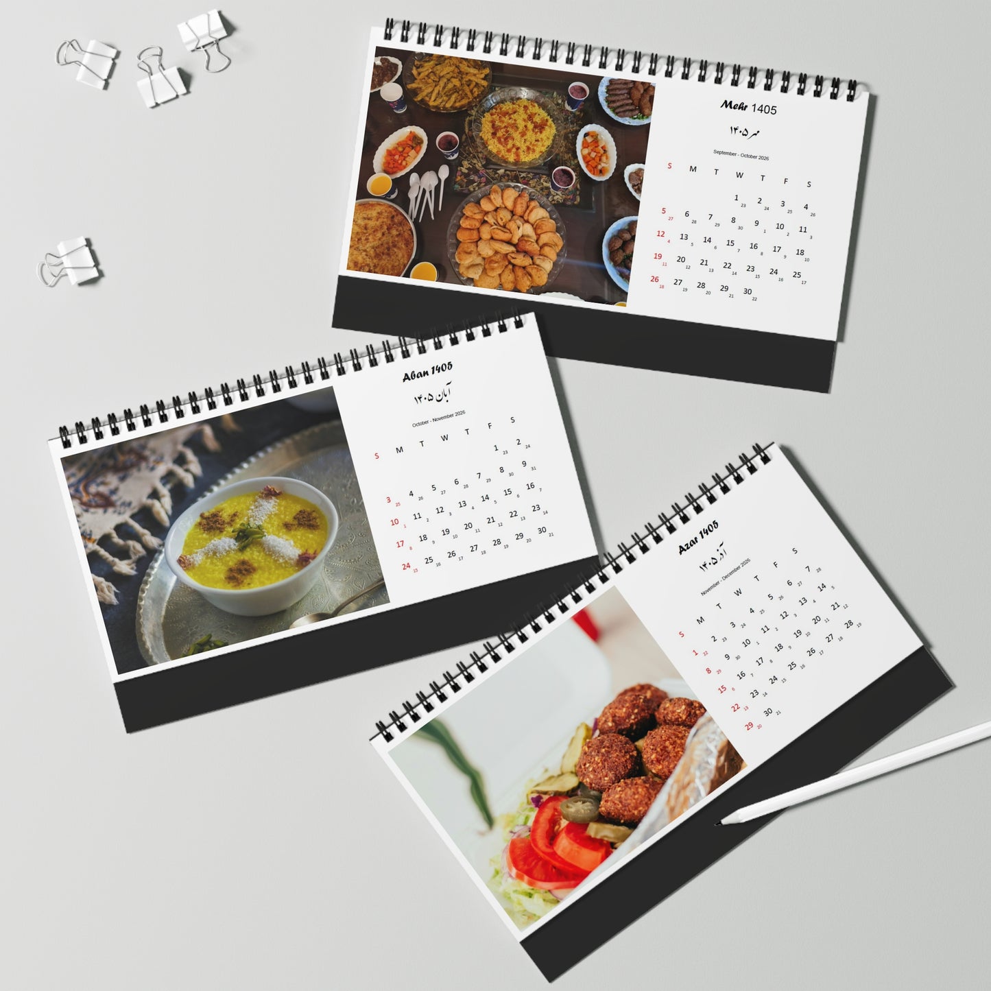 Three spiral-bound calendars with persian iranian food images on a gray background